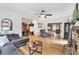 Open living room with hardwood floors, ceiling fan, stone fireplace, and lots of natural light at 1637 Willow Way, Woodstock, GA 30188