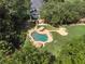 Aerial view of the private backyard oasis featuring a pool, hot tub, mature landscaping and a spacious patio area at 2390 Sassafrass Ln, Powder Springs, GA 30127