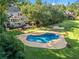 Aerial view of the kidney-shaped pool surrounded by lush green landscaping and backyard amenities at 2390 Sassafrass Ln, Powder Springs, GA 30127