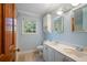 Bright bathroom with double vanity, a linen cabinet, a window, and a wood door at 2390 Sassafrass Ln, Powder Springs, GA 30127