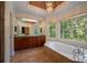 Luxurious bathroom with a soaking tub, dual vanities, and a large window at 2390 Sassafrass Ln, Powder Springs, GA 30127