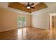 Bright bedroom with tray ceiling, hardwood floors, and French doors leading to balcony at 2390 Sassafrass Ln, Powder Springs, GA 30127