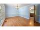 Dining room with hardwood floors, light blue walls with white wainscoting, and chandelier at 2390 Sassafrass Ln, Powder Springs, GA 30127