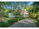 Charming two-story home features a welcoming double-decker porch, lush landscaping, and a private driveway at 2390 Sassafrass Ln, Powder Springs, GA 30127