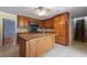 Spacious kitchen featuring custom wood cabinets, a granite island, and tile flooring at 2390 Sassafrass Ln, Powder Springs, GA 30127