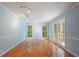Bright living room with hardwood floors, light blue walls, and large windows overlooking the backyard at 2390 Sassafrass Ln, Powder Springs, GA 30127