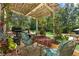 Inviting outdoor dining area features a pergola, comfortable seating, and a grill, perfect for entertaining at 2390 Sassafrass Ln, Powder Springs, GA 30127