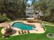 A stunning backyard features a large in-ground pool, diving board, patio with seating, and lush landscaping at 2390 Sassafrass Ln, Powder Springs, GA 30127