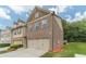 Side view of a brick townhome with manicured lawn, showcasing the attached two-car garage and neat landscaping at 3255 Clear View Dr, Snellville, GA 30078