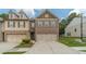 Charming brick townhome featuring a two-car garage and a well-maintained lawn with lush greenery at 3255 Clear View Dr, Snellville, GA 30078