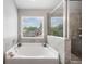 Bright bathroom with soaking tub, walk-in shower, and large window at 4460 Hunters Walk Way, Cumming, GA 30028