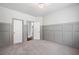 Clean bedroom with neutral carpet, wainscoting and two entry doors at 4460 Hunters Walk Way, Cumming, GA 30028