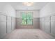 Empty bedroom with neutral carpet, wainscoting and natural light from a large window at 4460 Hunters Walk Way, Cumming, GA 30028