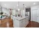 Open concept kitchen with large island, pendant lights, stainless appliances, open to living room at 4460 Hunters Walk Way, Cumming, GA 30028