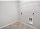 This laundry room features tile flooring, washer/dryer hookups, and a wire shelf for storage at 4460 Hunters Walk Way, Cumming, GA 30028