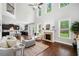 Bright living room with hardwood floors, fireplace, tall windows and an open concept to the kitchen at 4460 Hunters Walk Way, Cumming, GA 30028