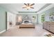 Spacious main bedroom with tray ceiling, ceiling fan, ensuite bath, and neutral color palette at 4460 Hunters Walk Way, Cumming, GA 30028