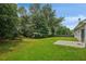 Spacious backyard featuring lush green grass, mature trees, and a concrete patio perfect for outdoor enjoyment at 3025 Andora Sw Dr, Marietta, GA 30064
