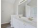 Bathroom features double sinks, a large mirror, white cabinets, and hardwood floors at 3025 Andora Sw Dr, Marietta, GA 30064