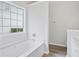 Bright bathroom features a large soaking tub next to a window, and wood look floors at 3025 Andora Sw Dr, Marietta, GA 30064