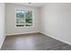 A sunlit bedroom features gray wood look flooring and a large window at 3025 Andora Sw Dr, Marietta, GA 30064