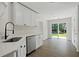 Bright kitchen features white cabinets, stainless steel appliances, and a sliding glass door to backyard at 3025 Andora Sw Dr, Marietta, GA 30064