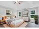 Staged primary bedroom features hardwood floors, tray ceiling, and 2 windows overlooking the back yard at 3025 Andora Sw Dr, Marietta, GA 30064