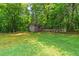 View of backyard with lawn and a storage shed and wooden fence at the back at 4655 Barnes Ct, Loganville, GA 30052