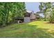 View of backyard with a screened in porch, deck, grassy lawn and trees at 4655 Barnes Ct, Loganville, GA 30052
