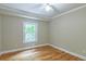 Bright bedroom featuring hardwood floors, a ceiling fan, and a window with a view of trees at 4655 Barnes Ct, Loganville, GA 30052