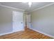 Spacious bedroom with hardwood floors, white doors, and neutral walls at 4655 Barnes Ct, Loganville, GA 30052