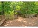 A spacious wooden deck surrounded by lush trees and a wooden gazebo-like structure at 4655 Barnes Ct, Loganville, GA 30052