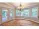 Elegant dining room with hardwood floors, chandelier, large windows, and screened-in patio access at 4655 Barnes Ct, Loganville, GA 30052