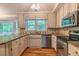 Updated kitchen boasts granite counters, stainless appliances, and hardwood flooring, with a view of nature at 4655 Barnes Ct, Loganville, GA 30052