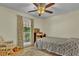 Neutral bedroom featuring a ceiling fan, gray patterned bedding, and a large window at 4794 Glenbonnie Ct, Atlanta, GA 30360