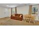 Cozy living room with a brown sofa, dining table, and windows overlooking the yard at 4794 Glenbonnie Ct, Atlanta, GA 30360