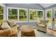 Comfortable sunroom features large windows, light wood floors, and cozy seating at 4794 Glenbonnie Ct, Atlanta, GA 30360