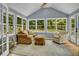 Vaulted sunroom with lots of natural light, chair, couch and views of the backyard at 4794 Glenbonnie Ct, Atlanta, GA 30360