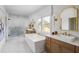 Luxurious bathroom featuring a soaking tub, glass-enclosed shower, double vanities, and a large window offering natural light at 4820 Gadwall Way, Cumming, GA 30028