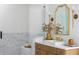 Stylish bathroom showcasing a glass shower, marble accents, vanity with gold fixtures, and decorative gold mirror at 4820 Gadwall Way, Cumming, GA 30028