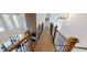 Bright hallway with wood floors, and decorative black metal railings and newel posts, offering natural light and elegant design at 4820 Gadwall Way, Cumming, GA 30028
