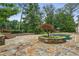 Stunning stone patio featuring a custom in-ground pool and mature landscaping at 511 Pine Valley Se Rd, Marietta, GA 30067