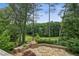 Secluded backyard features a stone patio, lush greenery, and views of a lush golf course beyond at 511 Pine Valley Se Rd, Marietta, GA 30067