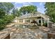 Expansive backyard with pool, stone patio, lush landscaping, and multi-story home at 511 Pine Valley Se Rd, Marietta, GA 30067