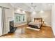 This bedroom has hardwood floors, a window seat, a ceiling fan, and a fireplace at 511 Pine Valley Se Rd, Marietta, GA 30067