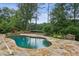 Tranquil pool with a stone surround and lush landscaping, providing a serene outdoor retreat at 511 Pine Valley Se Rd, Marietta, GA 30067