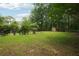 Expansive backyard with mature trees, a small shed, and ample space for outdoor recreation and landscaping at 285 Aspen Way, Fayetteville, GA 30214
