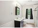 Bathroom featuring a modern vanity, decorative mirror, tiled floors, toilet, window and shower/tub combo at 285 Aspen Way, Fayetteville, GA 30214