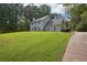 Traditional two-story home featuring a lush front yard, mature trees, and a charming covered entryway at 285 Aspen Way, Fayetteville, GA 30214