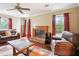 A cozy living room featuring a brick fireplace, hardwood floors, and comfortable brown leather furniture at 285 Aspen Way, Fayetteville, GA 30214